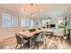 Open concept dining area with modern chandelier, wood floors, and seating for six at 391 Capistrano Vistas St, Las Vegas, NV 89138