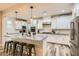 Beautiful white kitchen with stainless steel appliances, granite countertops, and center island with bar stool seating at 391 Capistrano Vistas St, Las Vegas, NV 89138