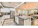 Modern kitchen with stainless steel appliances, granite countertop island, and open floor plan to dining area at 391 Capistrano Vistas St, Las Vegas, NV 89138