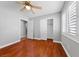 Bright bedroom features a ceiling fan, closet, a window with shutter blinds, and hardwood floors at 4029 Ricebird Way, North Las Vegas, NV 89084