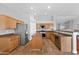 Open concept kitchen featuring granite countertops, tile floors, wooden cabinets, and stainless steel appliances at 4029 Ricebird Way, North Las Vegas, NV 89084