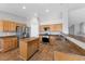 Kitchen with stainless steel appliances, island, tile floor, wooden cabinets and trim, and lots of recessed lighting at 4029 Ricebird Way, North Las Vegas, NV 89084