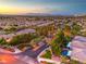 Sunset aerial view of a residential area with pools, landscaping, and lush greenery enhancing each home's charm at 4045 Abernethy Forest Pl, Las Vegas, NV 89141