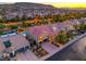 Scenic aerial view of a home with a red-tiled roof, palm trees, and mountain backdrop at 4045 Abernethy Forest Pl, Las Vegas, NV 89141
