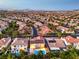 Wide aerial view of a residential neighborhood featuring well-maintained homes and lush green landscaping under a twilight sky at 4045 Abernethy Forest Pl, Las Vegas, NV 89141