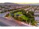 Scenic aerial view of a park with playground, trees, and lush landscaping nestled within a residential neighborhood at 4045 Abernethy Forest Pl, Las Vegas, NV 89141