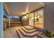Covered back patio leading to a kitchen, featuring tiled steps and stone accents at 4045 Abernethy Forest Pl, Las Vegas, NV 89141