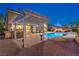 Backyard oasis with a covered patio, pool, and a brick paved deck at 4045 Abernethy Forest Pl, Las Vegas, NV 89141
