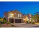 Elegant two-story home featuring a three-car garage, arched entry, stone accents, and lush landscaping at 4045 Abernethy Forest Pl, Las Vegas, NV 89141