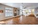 Living room with a stacked stone fireplace, bright windows, and beautiful wood-look flooring at 4045 Abernethy Forest Pl, Las Vegas, NV 89141