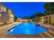 Backyard pool with multiple water features, adjacent spa, tiered landscaping, and privacy wall at 4045 Abernethy Forest Pl, Las Vegas, NV 89141