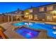 Backyard pool and spa with covered patio featuring an outdoor kitchen, and mature landscaping at 4045 Abernethy Forest Pl, Las Vegas, NV 89141