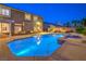 Backyard pool with integrated spa, covered patio, and mature landscaping under a night sky at 4045 Abernethy Forest Pl, Las Vegas, NV 89141