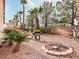 Spacious backyard with gravel, barbecue grill, and lush palm trees at 4314 Livorno Ave, Las Vegas, NV 89141