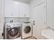 Functional laundry room with modern washer and dryer, along with ample cabinet space for storage at 4314 Livorno Ave, Las Vegas, NV 89141
