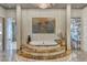The primary bath features an elevated tub, a mosaic accent wall, and artistic tree-inspired glass doors at 4525 Dean Martin Dr # 2503, Las Vegas, NV 89103
