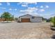 Side exterior view of the home showing the garage and the surrounding desert landscape at 4981 E Pawnee Pl, Pahrump, NV 89061