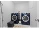 Modern laundry room with blue front-load washer and dryer at 4981 E Pawnee Pl, Pahrump, NV 89061