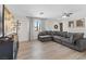 Spacious living room featuring a large gray sectional couch and a modern ceiling fan at 4981 E Pawnee Pl, Pahrump, NV 89061