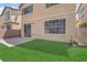Backyard with sliding glass door, artificial grass, and rock landscaping at 5653 Mount Athos St, North Las Vegas, NV 89031