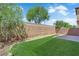 Backyard featuring a brick wall, rock landscaping, and artificial grass at 5653 Mount Athos St, North Las Vegas, NV 89031