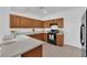 Kitchen with wood cabinetry, stainless steel appliances, and tiled floor, perfect for cooking and entertaining at 5653 Mount Athos St, North Las Vegas, NV 89031