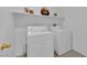 Bright laundry room with washer, dryer, storage shelves, and fresh paint at 5653 Mount Athos St, North Las Vegas, NV 89031