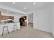 Open living space with neutral carpet, breakfast bar, and view into the kitchen with black appliances at 5653 Mount Athos St, North Las Vegas, NV 89031