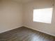 A simple bedroom with wood-look flooring and a window for natural light at 5751 E Hacienda Ave # 137, Las Vegas, NV 89122