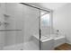 Bright bathroom with a glass enclosed shower, soaking tub, and window at 5936 Bruselas St, Las Vegas, NV 89113