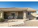 A cozy covered porch with patio furniture, a security door, and desert landscaping at 5950 Mojave St, Pahrump, NV 89061