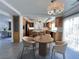 Sunlit kitchen featuring wood cabinets, stainless appliances, and an adjacent dining area with stylish modern light fixture at 6571 Abalone Shell Ct, Las Vegas, NV 89139