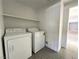 Functional laundry area with side-by-side washer and dryer, plus convenient overhead shelving at 6571 Abalone Shell Ct, Las Vegas, NV 89139