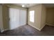 A carpeted bedroom with a window and vertical blinds for privacy at 6800 E Lake Mead Blvd # 2024, Las Vegas, NV 89156