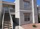 Two-story condo featuring a staircase leading to the upper units, neutral stucco, and well-maintained landscaping at 6800 E Lake Mead Blvd # 2024, Las Vegas, NV 89156