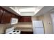 Compact kitchen featuring granite counters, white appliances, and wooden cabinets at 6800 E Lake Mead Blvd # 2024, Las Vegas, NV 89156