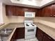 Compact kitchen featuring granite counters, white appliances, and wooden cabinets at 6800 E Lake Mead Blvd # 2024, Las Vegas, NV 89156