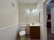 Half bathroom with a pedestal sink, well-lit vanity, wood-look floors, and white wainscoting at 6868 Sky Pointe Dr # 1118, Las Vegas, NV 89131