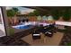 Luxury pool area with covered patio, outdoor seating, and desert landscaping at 7132 Sayonara Vista St, North Las Vegas, NV 89084