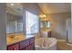 Bathroom showcasing double vanities, a soaking tub, and a glass-enclosed shower at 72 Broken Putter Way, Las Vegas, NV 89148