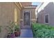Home's entry door features a decorative security gate and desert landscaping at 72 Broken Putter Way, Las Vegas, NV 89148