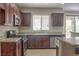 Stylish kitchen with stainless steel appliances, granite countertops, dark wood cabinets, and ample storage at 72 Broken Putter Way, Las Vegas, NV 89148