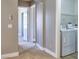 Hallway leading to the laundry room with washer and dryer, and additional storage shelves at 72 Broken Putter Way, Las Vegas, NV 89148