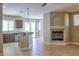 Open-concept living room featuring tile flooring, a cozy fireplace, and a kitchen with stainless steel appliances at 72 Broken Putter Way, Las Vegas, NV 89148