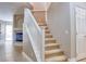 Carpeted stairs with white railing, close to the front door and featuring a view of the fireplace at 72 Broken Putter Way, Las Vegas, NV 89148