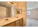 Bathroom with double sinks, and mirrors with lights above, along with a door to the shower at 7547 Rolling River Dr, Las Vegas, NV 89131