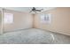 Spacious bedroom with gray carpet, neutral paint, a ceiling fan, and dual windows at 7547 Rolling River Dr, Las Vegas, NV 89131