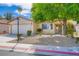 Traditional single-story home featuring a two-car garage, desert landscaping, and mature trees at 7547 Rolling River Dr, Las Vegas, NV 89131