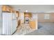 Bright and modern kitchen showcasing white appliances, wood cabinetry, and access to the living area at 7547 Rolling River Dr, Las Vegas, NV 89131