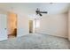 Bright main bedroom with a ceiling fan, plush gray carpet, and doorways to the bathroom and walk-in closet at 7547 Rolling River Dr, Las Vegas, NV 89131
